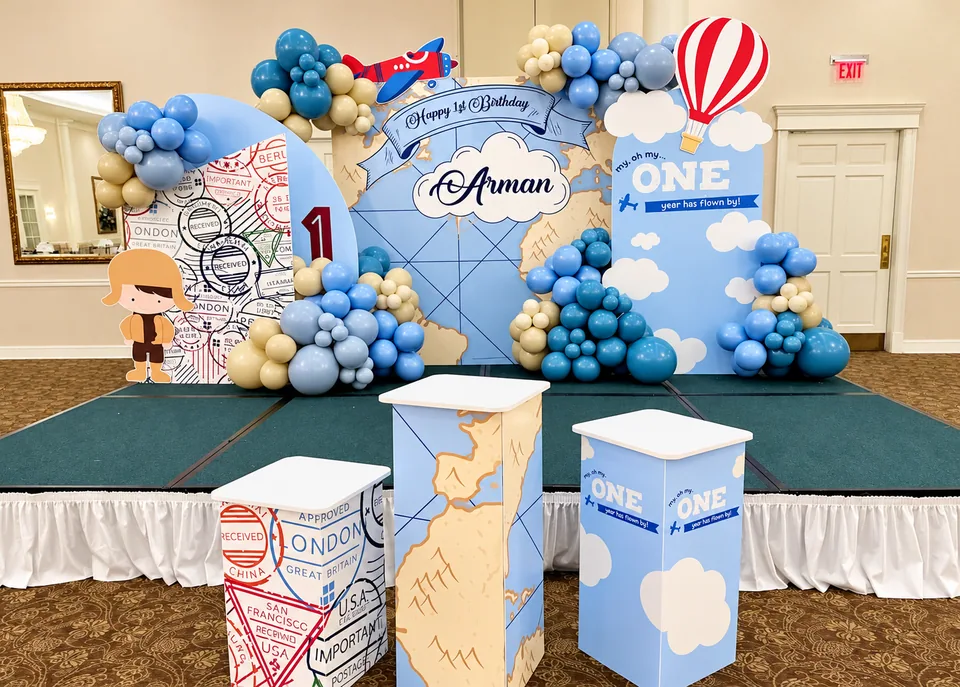 Around the world first birthday stage with hot air balloon, travel panels and display pedestals